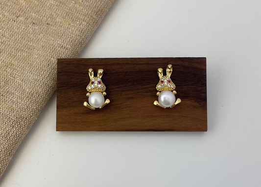 Pair of earrings on a wooden display card with a neutral background